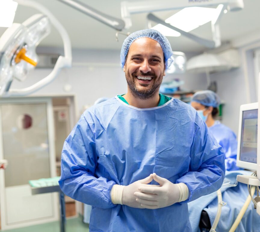 anesthetist working operating theatre wearing protecive gear checking monitors while sedating patient before surgical procedure hospital min scaled