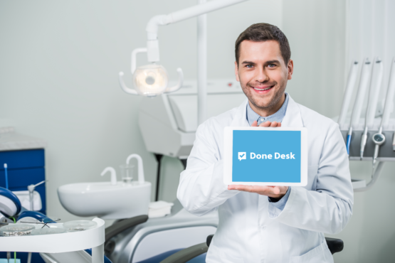 cheerful dentist in white coat holding digital tab 2023 11 27 04 51 39 utc