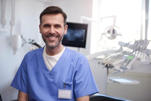 portrait of smiling dentist in dentists office N2YXDVN min scaled